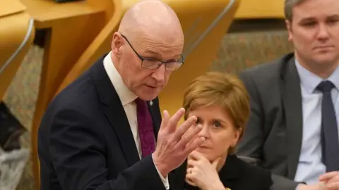 PA Media John Swinney during the budget debate