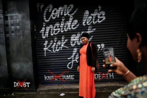 Simon Dawson / Reuters Worshippers take photos outside the House of Praise church