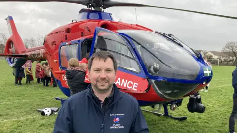 BBC Graham Coates in front of an air ambulance