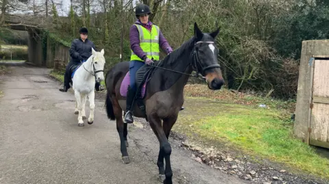 BBC News Lesley and her mum Wendy riding horses down a country path