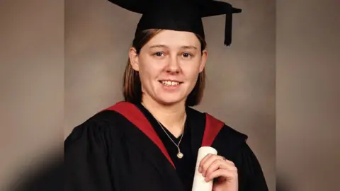 Julia Taylor Julia, younger than pictured earlier, in her graduation gown and cap, holding a scroll.