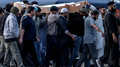 Getty Images A coffin containing the body of a victim of the Christchurch terrorist attack is carried for burial at Memorial Park Cemetery on March 20, 2019 in Christchurch