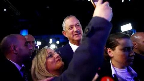 Reuters Benny Gantz poses for a selfie with a supporter at an election night gathering in Tel Aviv on 3 March 2020