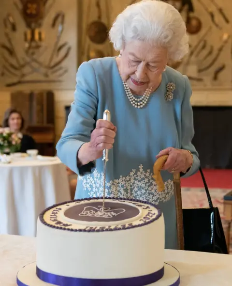 PA Media Queen Elizabeth II cutting a cake