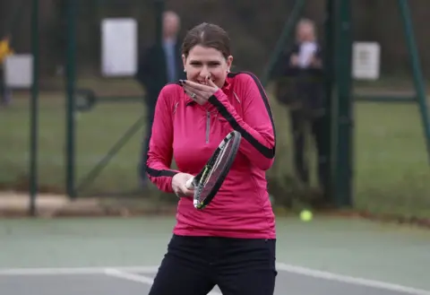 PA Media Jo Swinson with a tennis racket