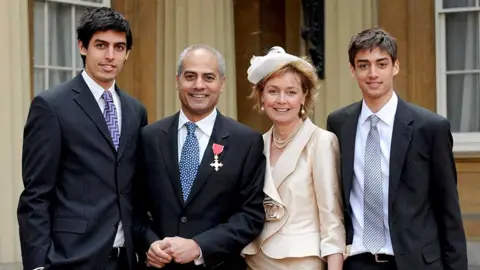 PA Media 2008: News reader George Alagiah accompanied by his wife Frances and sons Adam, 21, left and Matt, 17, at Buckingham Palace, after collecting his OBE from the Queen.