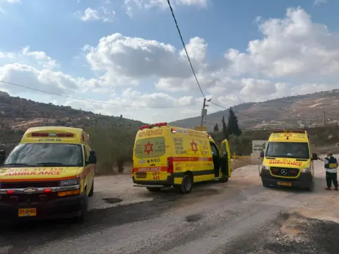 Magen David Adom Three yellow ambulances parked at scene of West Bank shooting incident (24/07/26)