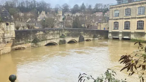 BBC A high river in Bradford-on-Avon with buildings in the background