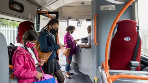 Getty Images Masked passengers on bus