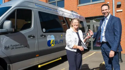 West Northamptonshire Council Lynn Hinch from Ability and councillor Dan Lister pose next to an Ability-branded bus