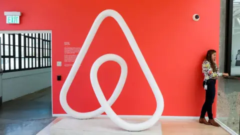 Reuters woman by Airbnb logo