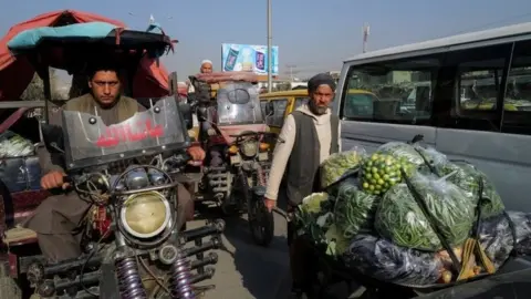 Reuters A man pushes wheelbarrow filled with vegetables and fruits at the market in Kabul, Afghanistan