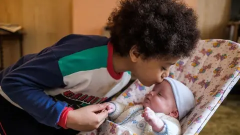 Leon kissing his baby brother