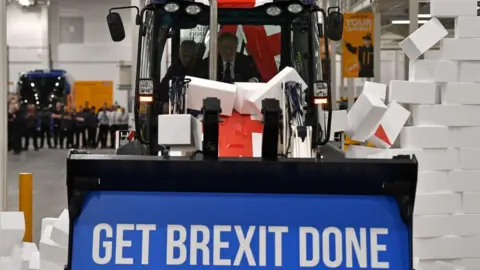 Getty Images Boris Johnson drives a Union flag-themed JCB, with the words "Get Brexit Done" inside the digger bucket