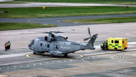 Royal Navy Helicopter and ambulance at RNAS Culdrose after kayaker rescued