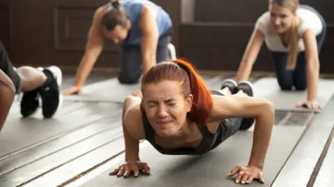 Getty Images woman in the gym doing planks