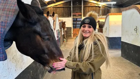 BBC News Kelly Harrop with one of the horses she looks after