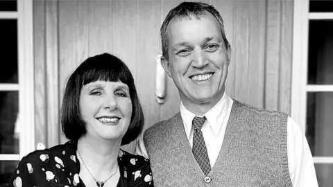 Lisa & Neil Fletcher outside their house