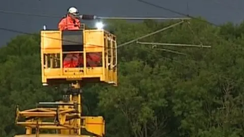 Engineers fixing overhead rail cables