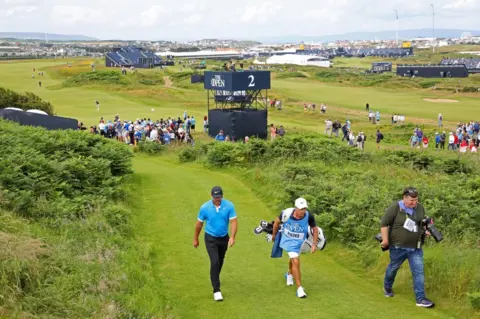PA Media Brooks Koepka and Ricky Elliott walk away from the second hole at Royal Portrush