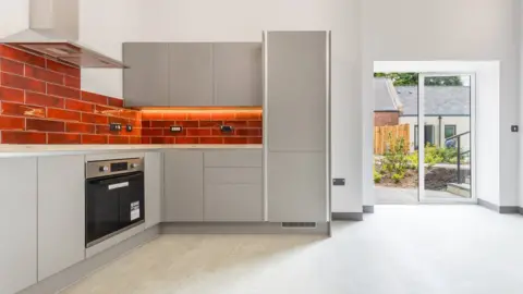 Sunderland City Council The inside of an apartment as seen from the kitchen, with a garden in the background