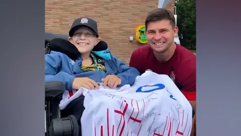 England Rugby Charlie with members of the England Men's Rugby Union team