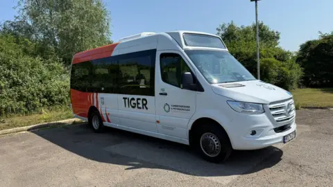 Image of a red and white bus with "Tiger" written on the side