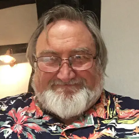 Supplied John Peters wearing a flowery shirt