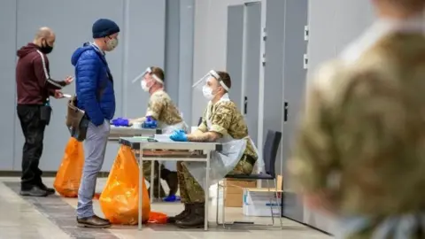 Reuters Soldiers talk to people at The Exhibition Centre, in Liverpool, which has been set up as a testing centre as part of the mass coronavirus disease