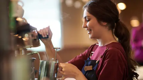 A Costa Coffee barista making a drink