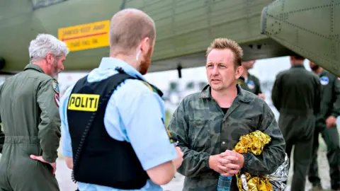 AFP Peter Madsen talks to a police officer on Friday August 11 after being rescued