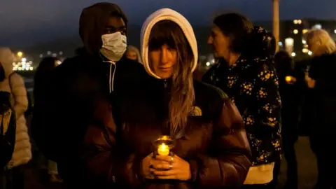 Getty Images Locals gathered on Dover seafront for a candlelit vigil to mark the tragic death of the Kurdish-Iranian family who lost their lives attempting to seek asylum, on the 30th of October 2020 in Dover, United Kingdom.