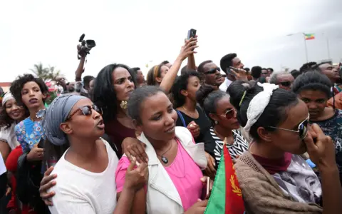 AFP Eritreans wait to welcome their families at Asmara International Airport aboard the Ethiopian Airlines ET314 flight in Asmara, Eritrea July 18, 2018.