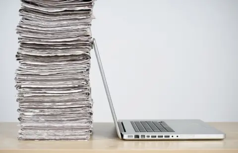 Getty Images laptop and newspapers