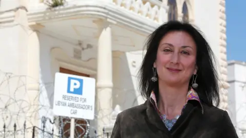 Reuters Maltese investigative journalist Daphne Caruana Galizia poses outside the Libyan Embassy in Valletta April 6, 2011.