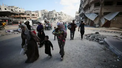 Getty Images Palestinians leave on 12 Oct after IDF order to eave area D5 on its map of Gaza