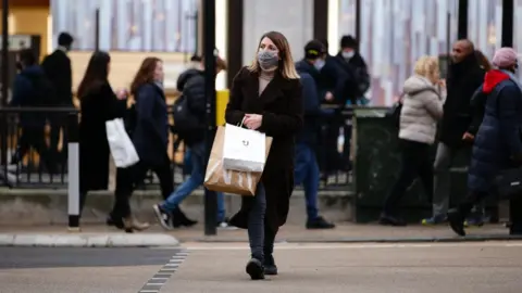 Getty Images Shopper crossing the road.