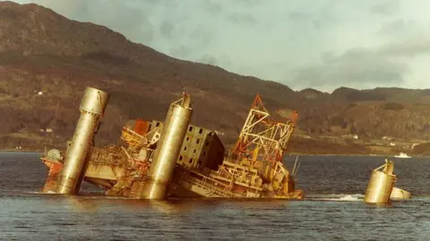 Unknown/Norwegian Petroleum Museum Wreck of a rig in a fjord