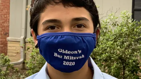 Rachel Lopatin Gideon wearing a mask that reads "Gideon's Bar Mitzvah 2020"