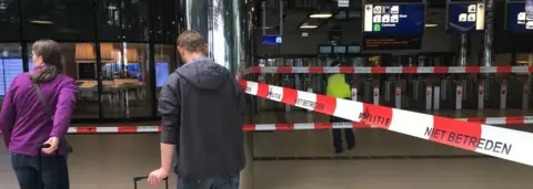 AFP Passengers wait behind cordon on 31 August