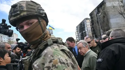 AFP UN Secretary-General Antonio Guterres (C) walks during his visit in Borodianka, outside Kyiv, on April 28, 2022