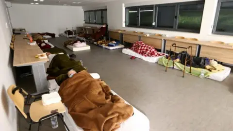 Reuters Displaced people sleep at a military base after an earthquake in Petrinja