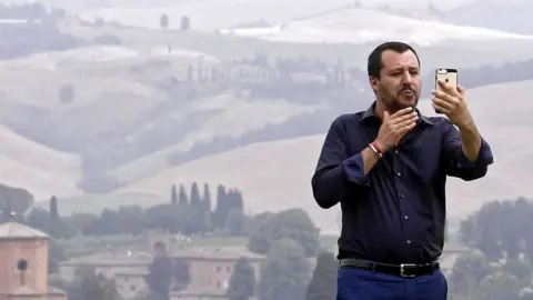 EPA Interior Minister Matteo Salvini poses for a selfie during a visit to an estate which was permanently confiscated in 2007 from the mafia