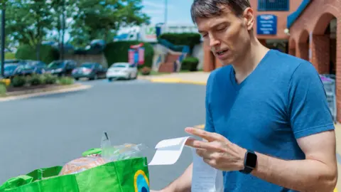 Getty Images Man looks at receipt