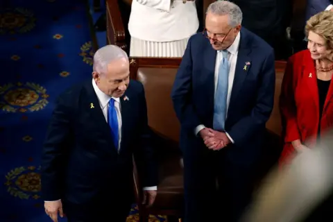 Getty Images Schumer watches as Israeli Prime Minister Benjamin Netanyahu arrives before he addresses a joint meeting of Congress in the chamber of the House of Representatives at the US Capitol in July 2024