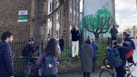 Ella Nunn/PA Wire Crowd of people standing in front of suspected Banksy mural