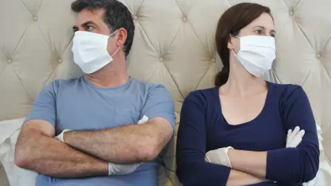 Getty Images Couple wearing PPE and not talking