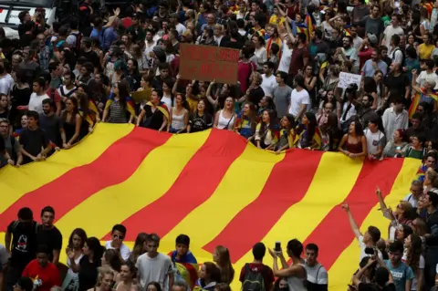 Susana Vera/REUTERS People carry a huge flag and placards during a demonstration two days after the banned independence referendum in Barcelona, Spain, 3 October 2017.
