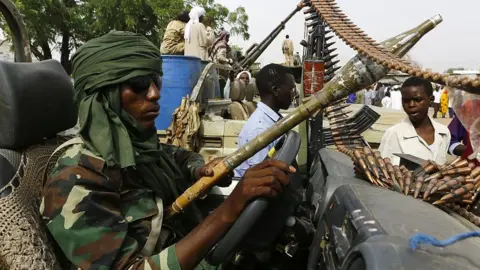 Getty Images A fighter from the Sudanese Rapid Support Forces sits in an armed vehicle in the city of Nyala, in south Darfur, on May 3, 2015, as they display weapons and vehicles they say they captured from Dafuri rebels and fighters from The Justice and Equality Movement (JEM), lead by opposition leader Jibril Ibrahim, the previous week