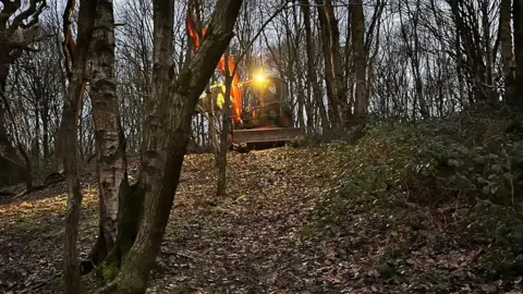 Dr Drainage Excavator in the woods in Pudsey, during a dog rescue